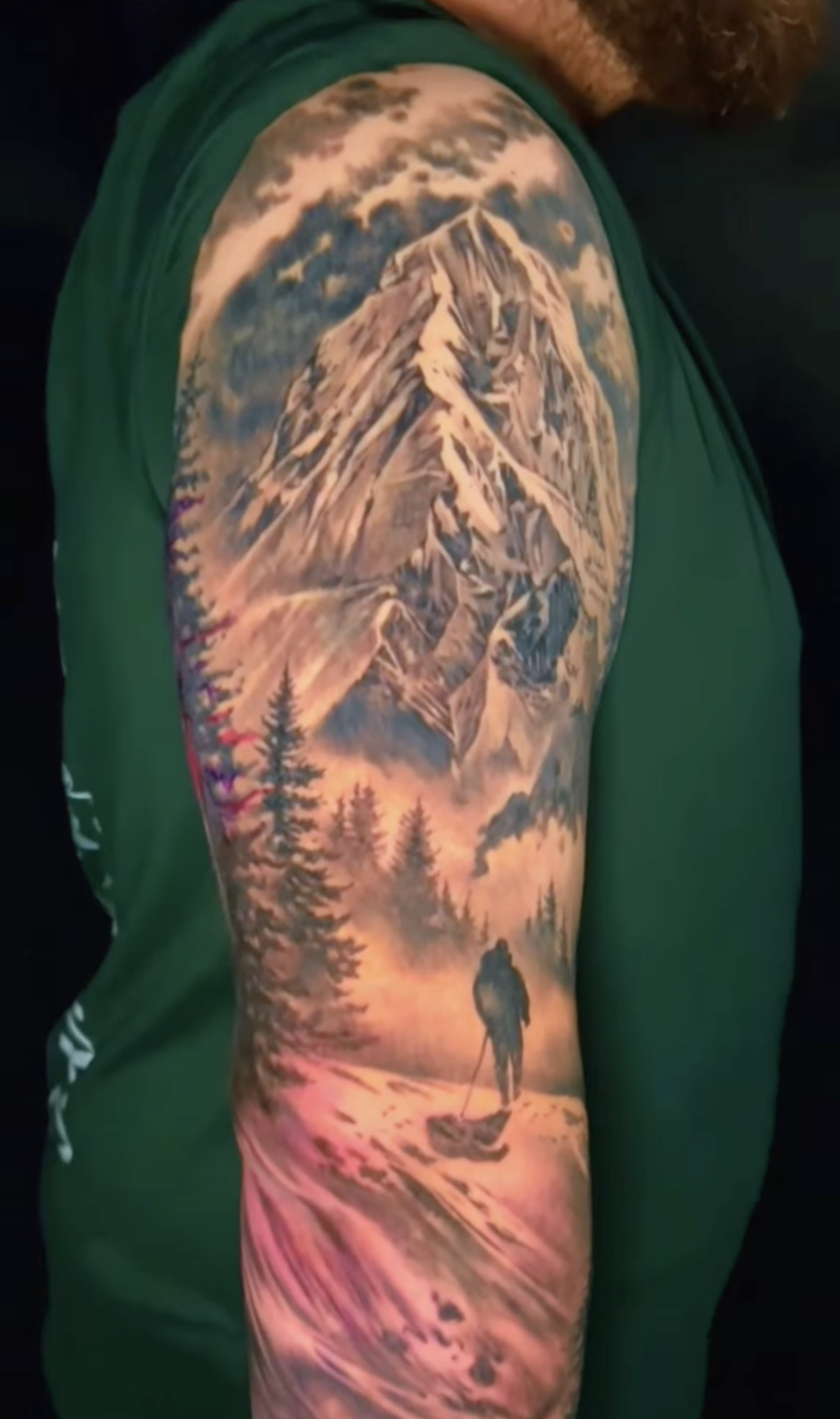 Großes, realistisches Tattoo einer majestätischen Berglandschaft mit einem Wanderer im Schnee